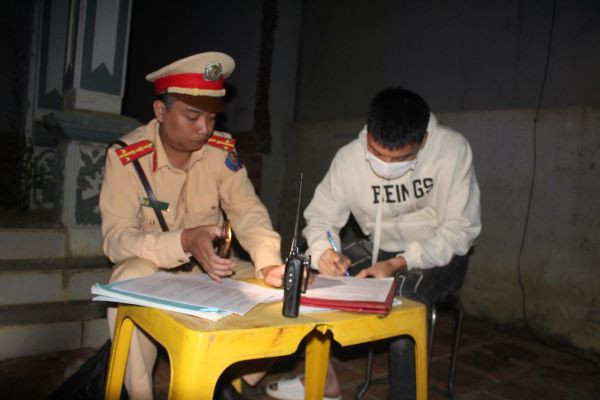 Tổ công tác Đội CSGT - TT Công an huyện Bắc Yên lập biên bản và yêu cầu tài xế kí vào biên bản vi phạm.