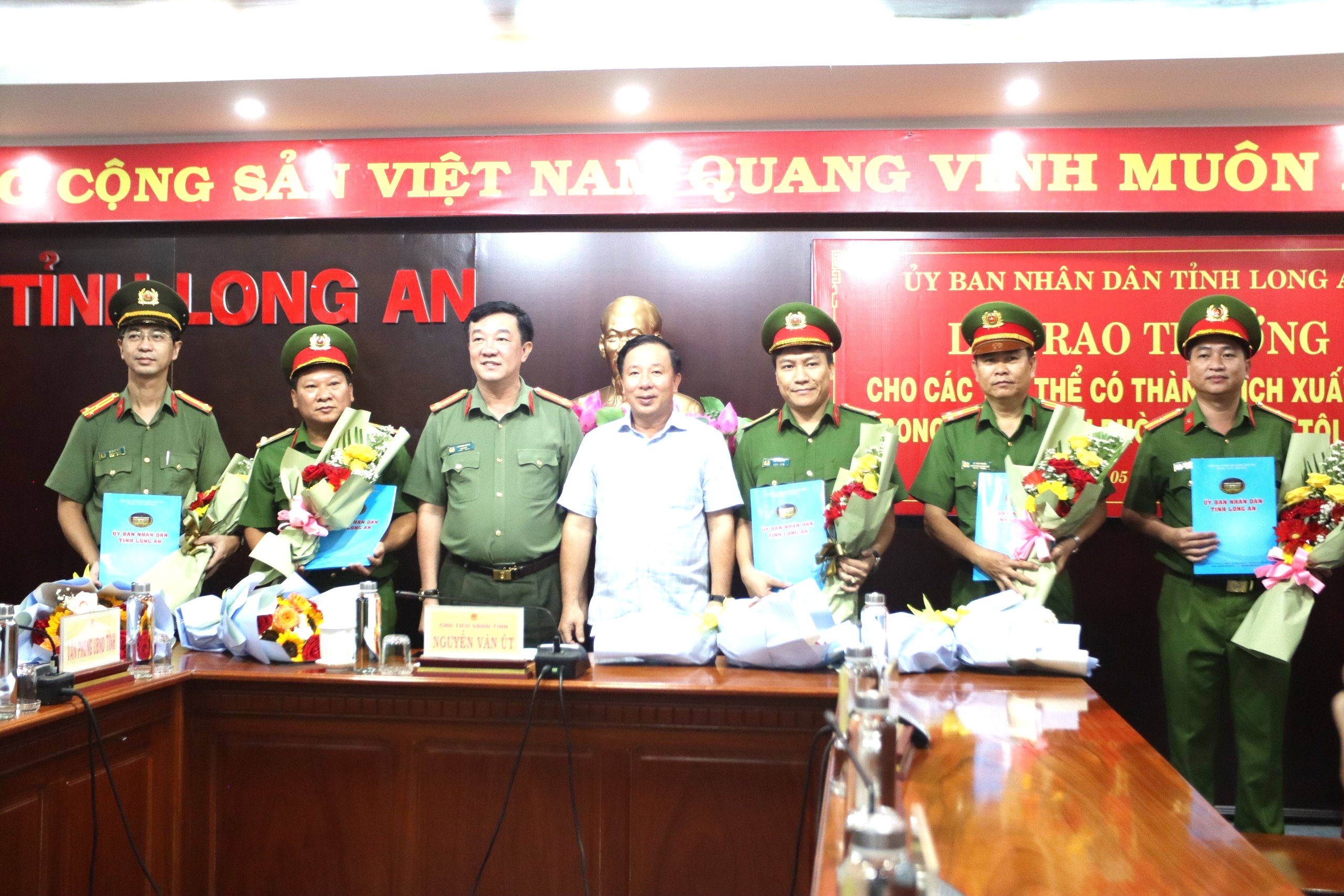 Ông Nguyễn Văn Út - Phó Bí thư Tỉnh ủy, Chủ tịch UBND tỉnh trao quyết định thưởng nóng cho các tập thể. (Ảnh: Công an Long An)