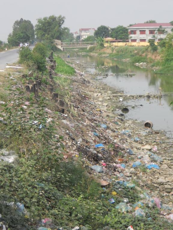 Con sông nhỏ chảy qua làng cũng tràn ngập rác và k