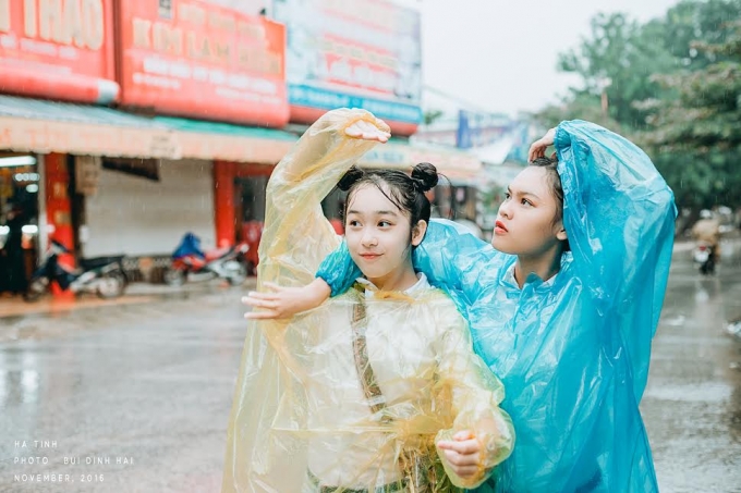Ho&agrave;i Thương (&aacute;o v&agrave;ng) v&agrave; Huyền Trang dưới cơn mưa m&ugrave;a lũ.