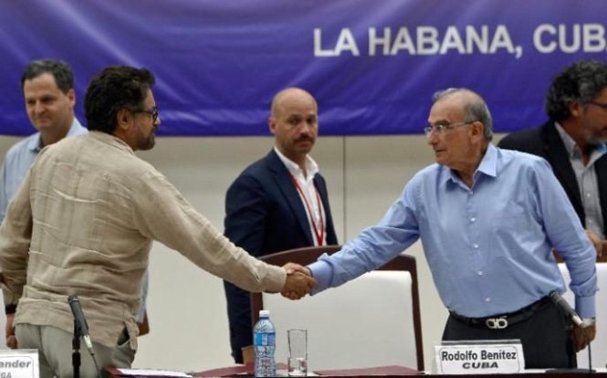 Đại diện ch&iacute;nh phủ Colombia (phải) v&agrave; đại diện FARC bắt tay tại Havana. (Ảnh: AFP)