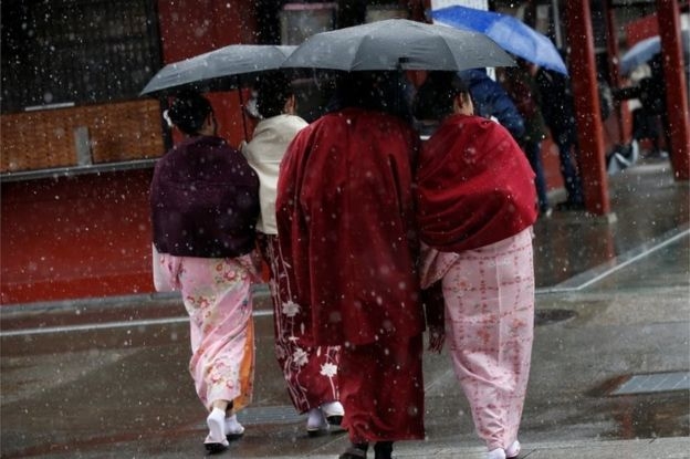 Phụ nữ Nhật mặc trang phục kimono ra đường ngắm tuyết rơi. (Ảnh: Reuters)