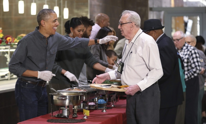 Tổng thống Obama lu&ocirc;n vui vẻ bắt tay v&agrave; nở nụ cười th&acirc;n thiện đối với c&aacute;c cựu binh. &Ocirc;ng phục vụ m&oacute;n g&agrave; t&acirc;y v&agrave; nước sốt. (Ảnh: AP)