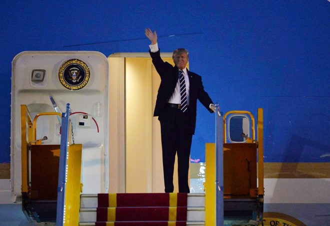 Tổng thống Trump đứng tr&ecirc;n cửa chuy&ecirc;n cơ Air Force One ở s&acirc;n bay Nội B&agrave;i vẫy ch&agrave;o mọi người. Ảnh: Zing.