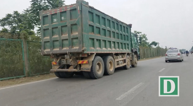 Một xe tải chở c&aacute;t kh&ocirc;ng che bạt, th&ugrave;ng cơi nới hoạt động tr&ecirc;n đường gom Đại lộ Thăng Long.