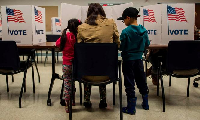 Trong ảnh, một người phụ nữ c&ugrave;ng 2 con nhỏ đi bỏ phiếu ở Lorton (bang Virginia). Ảnh: AFP