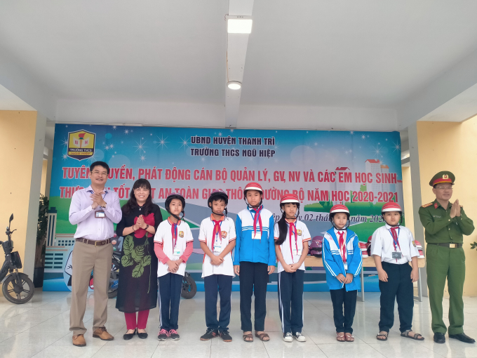 Bà Nguyễn Thị Tuyết Lê - TP Giáo dục và Thượng tá Nguyễn Mạnh Dầu tặng mũ bảo hiểm cho các em (Ảnh Mạnh Hùng)