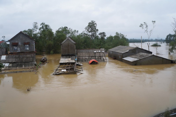 Nước lũ ngập ngang nóc nhà dân (Ảnh chụp trưa 12/11, tại Tổ dân phố Trạch Tả, thị trấn Phong Điền).