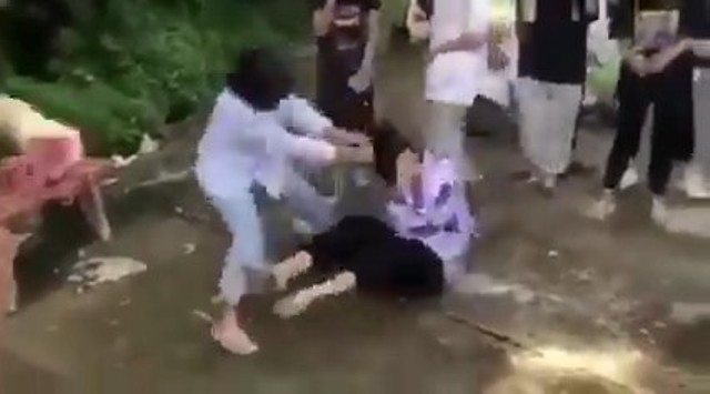 Nữ sinh liên tục bị đánh trong tiếng reo hò, cổ vũ của gần 2 chục học sinh khác vây quanh. (Ảnh cắt từ clip)