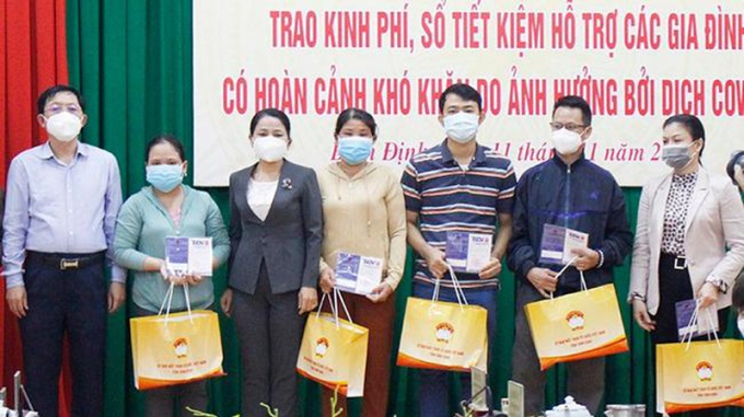 Lãnh đạo tỉnh Bình Định trao sổ tiết kiệm cho các gia đình có người tử vong do nhiễm COVID-19. (Ảnh: Anh Phương)