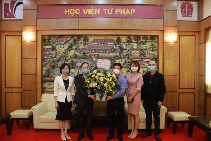 Phó Tổng Biên tập thường trực Trần Đức Vinh tặng lẵng hoa chúc mừng cho Giám đốc Học viện Tư pháp Nguyễn Xuân Thu.