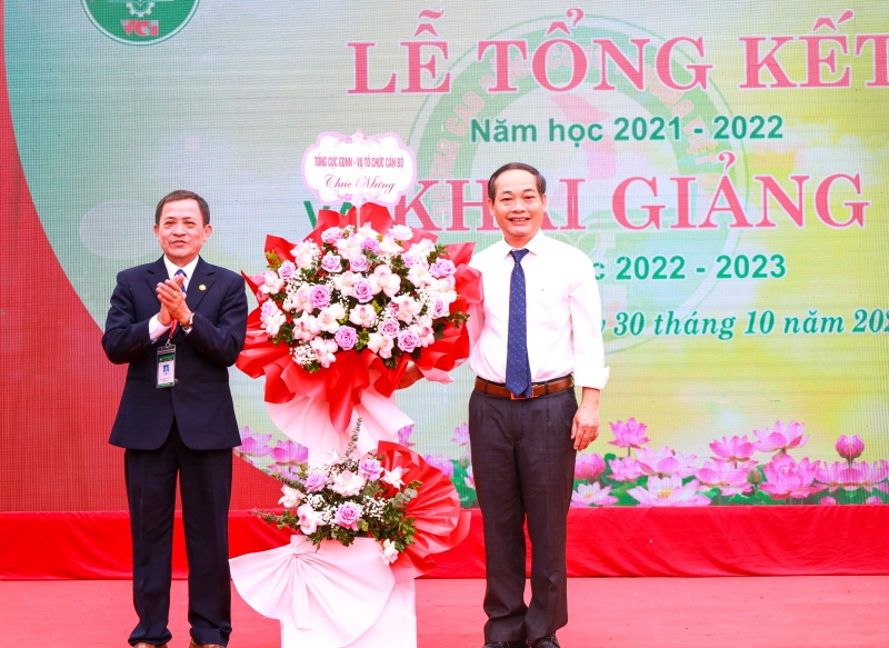 Ông Trần Quốc Huy, Vụ trưởng Vụ TCCB (Tổng cục GDNN) thay mặt lãnh đạo tổng cục tặng hoa chúc mừng nhà trường.