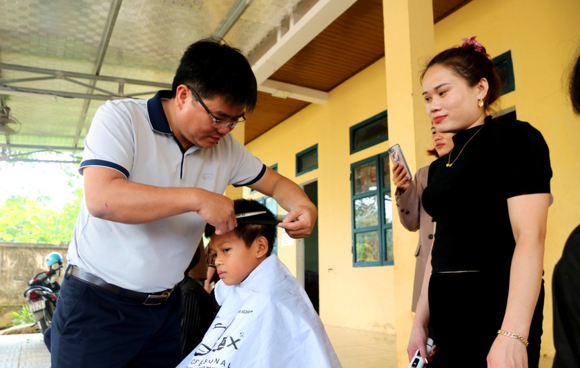 Thầy Hiệu trưởng Nguyễn Hữu Tâm cùng các tình nguyện viên cắt tóc miễn phí cho các học sinh người Mã Liềng.