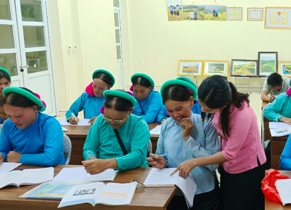 Cô giáo Phan Thị Hiền soát lại lỗi chính tả của học viên lớp xóa mù chữ Thôn Ngàn Pạt, xã Lục Hồn