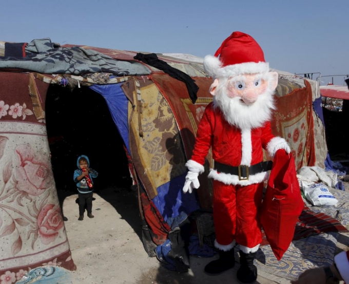 &Ocirc;ng gi&agrave; Noel tặng qu&agrave; cho những đứa trẻ ngh&egrave;o ở khu d&acirc;n cư ngh&egrave;o tại Najaf, ph&iacute;a nam thủ đ&ocirc; Baghdad. (Ảnh: Reuters)