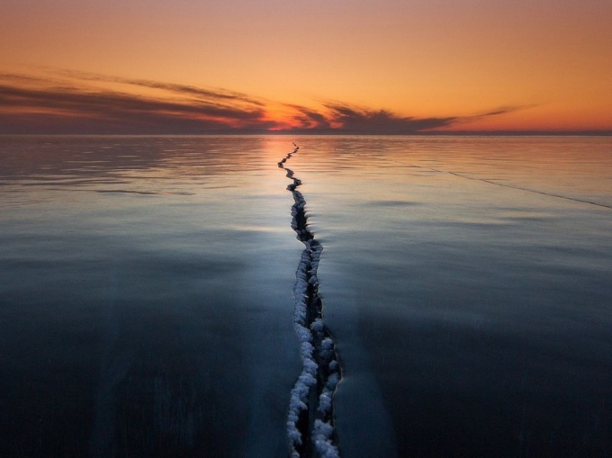 &ldquo;Băng tr&ecirc;n hồ Baikal (Siberia) l&agrave; một hiện tượng thi&ecirc;n nhi&ecirc;n th&uacute; vị&rdquo;, nhiếp ảnh gia Alexey Trofimov viết. &ldquo;C&aacute;c khe băng, vết nứt, chỗ t&aacute;ch rời, chỗ x&ocirc; l&ecirc;n nhau - tất cả tạo ra những c&acirc;u chuyện độc đ&aacute;o v&agrave; tuyệt vời&rdquo;. Trong chuyến đi tới hồ nước ngọt s&acirc;u nhất v&agrave; cổ nhất thế giới n&agrave;y, &ocirc;ng hy vọng chụp được một bức ảnh lạ thường tr&ecirc;n mặt băng. Một buổi s&aacute;ng, sương gi&aacute; v&agrave; gi&oacute; mạnh đ&atilde; tạo ra h&igrave;nh dạng đặc biệt của khe nứt. &Ocirc;ng cho biết: &ldquo;T&ocirc;i chỉ cần chờ tới l&uacute;c mặt trời mọc để chụp bức ảnh n&agrave;y&rdquo;. Ảnh:&nbsp;Alexey Trofimov.