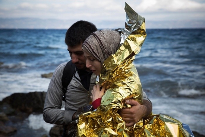 Bức ảnh cặp vợ chồng Syria tị nạn tới đảo Lesbos của Hy Lạp h&ocirc;m 30/9. Bức ảnh khiến người xem kh&ocirc;ng khỏi x&uacute;c động trước h&igrave;nh ảnh những người phải liều mạng sống để tho&aacute;t cảnh xung đột v&agrave; đ&oacute;i ngh&egrave;o ở qu&ecirc; hương. T&aacute;c giả: Santi Palacios. Ảnh: AP