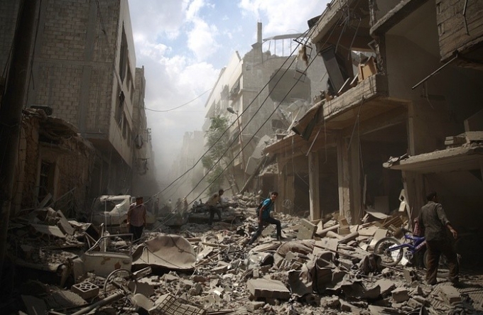 Người d&acirc;n Syria đi giữa đống đổ n&aacute;t của những t&ograve;a nh&agrave; bị ph&aacute; hủy sau cuộc kh&ocirc;ng k&iacute;ch của lực ch&iacute;nh phủ v&agrave;o phe nổi dậy tại khu vực Douma, ngoại &ocirc; thủ đ&ocirc; Damascus, ng&agrave;y 30/8. T&aacute;c giả: Abd Doumany. Ảnh: Getty