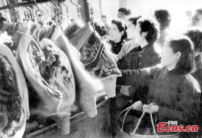 Một bức ảnh ghi lại cảnh c&aacute;c b&agrave; nội trợ đi chợ mua thịt lợn từ năm 1966 tại một cửa h&agrave;ng ở Thượng Hải. V&agrave;o những năm của thập ni&ecirc;n 60, mua sắm vẫn c&ograve;n bị giới hạn tại Trung Quốc. Người ta chỉ được mua số lượng thực phẩm tương đương với c&aacute;c tem phiếu được ph&aacute;t mỗi th&aacute;ng giống như tại Việt Nam. C&aacute;c loại thẻ như