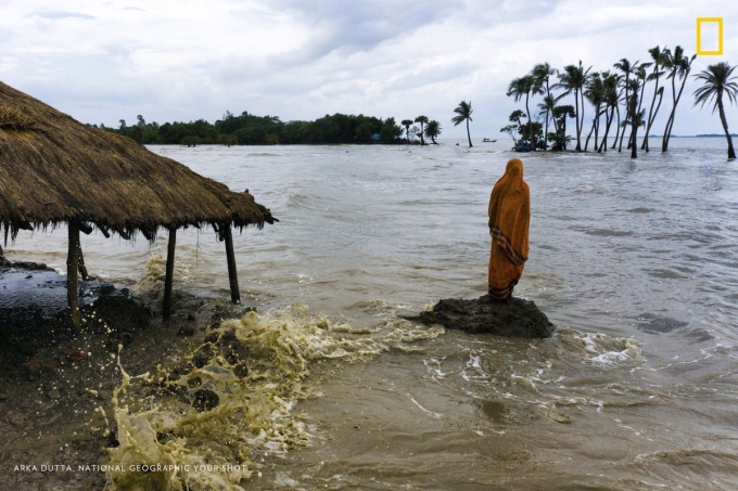 Một người phụ nữ đứng tr&ecirc;n h&ograve;n đảo Mousuni, Ấn Độ - nơi sự gia tăng của mực nước biển buộc người d&acirc;n phải từ bỏ vĩnh viễn l&agrave;ng qu&ecirc; của họ.