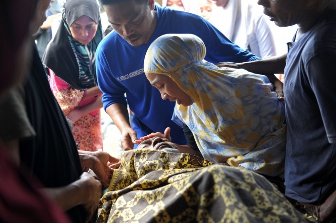 Một người phụ nữ đau buồn b&ecirc;n cạnh th&acirc;n nh&acirc;n đ&atilde; chết trong vụ động đất ở tỉnh Aceh, Indonesia. (Ảnh: Chaideer Mahyuddin / AFP / Getty Images)
