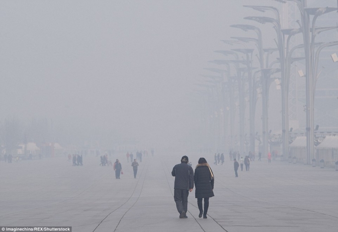 Người đi bộ tr&ecirc;n đường phố Bắc Kinh bị bao phủ bởi sương m&ugrave; d&agrave;y đặc dẫn đến tầm nh&igrave;n thấp.