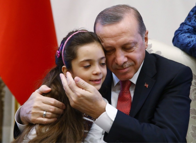 Tổng thống Erdogan tr&igrave;u mến &ocirc;m b&eacute; Bana v&agrave;o l&ograve;ng.