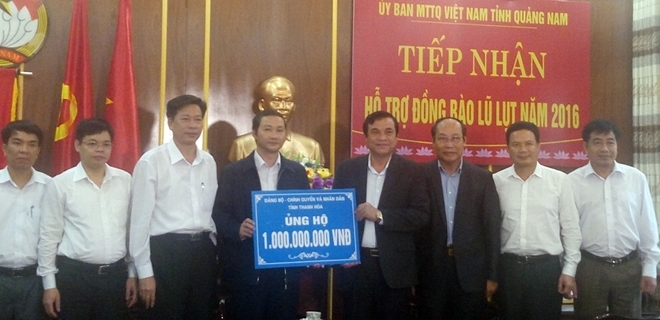 L&atilde;nh đạo tỉnh Quảng Nam tiếp nhận tiền hỗ trợ khắc phục hậu quả sau mưa lũ từ Thanh H&oacute;a. (Ảnh: cand.com.vn)