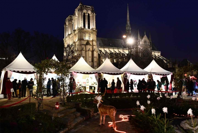 Đ&aacute;m đ&ocirc;ng mua sắm tại một hội chợ đ&ecirc;m Gi&aacute;ng sinh gần nh&agrave; thờ Notre-Dame, Paris. (Ảnh: Miguel Medina / AFP / Getty Images)