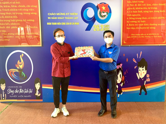 Anh Nguyễn Sỹ Hiền trao chiếc bánh mang hình ảnh và slogan cổ động chống dịch cho Bí thư Tỉnh Đoàn Bình Phước Trần Quốc Duy (bìa phải)