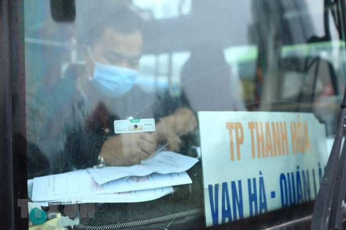 Phụ xe Trần Văn Hợp - nhà xe Tùng Lâm (tuyến Thanh Hóa - Hà Nội) khai báo y tế danh sách hành khách lên xe tại Bến xe Giáp Bát. (Ảnh: Hoàng Hiếu/TTXVN)