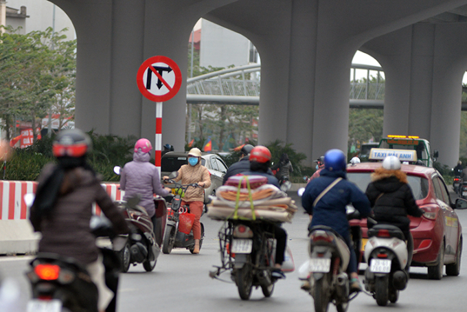 Mặc cho ô tô từ đi trên Vành đai 3 trên cao xuống đường Phạm Văn Đồng. Bất chấp biển báo, các xe máy vẫn cố tình xi nhan, quay đầu để đi ngược lối vào đường Trần Cung.