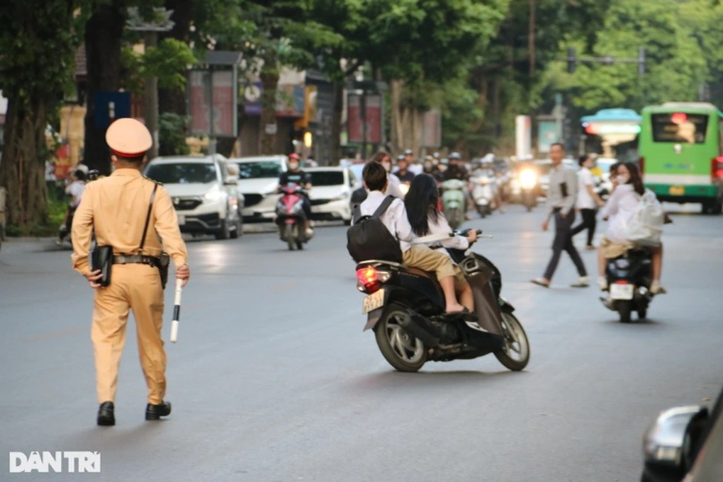 Học sinh không đội mũ bảo hiểm điều khiển xe máy quay xe bỏ chạy khi thấy cảnh sát giao thông. (Ảnh: Trần Thanh)