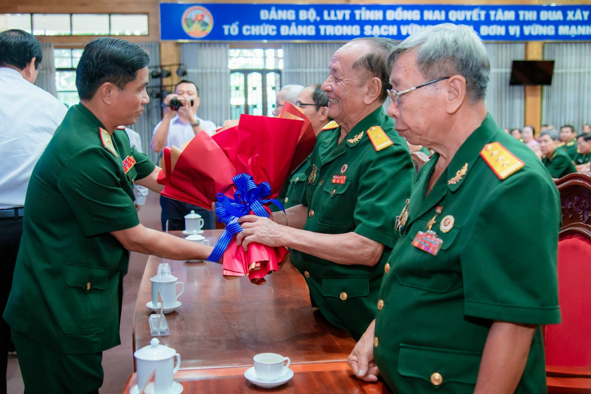 Lãnh đạo Quân khu 7 tặng hoa tri ân các đại biểu là Anh hùng lực lượng vũ trang nhân dân tại buổi họp mặt.